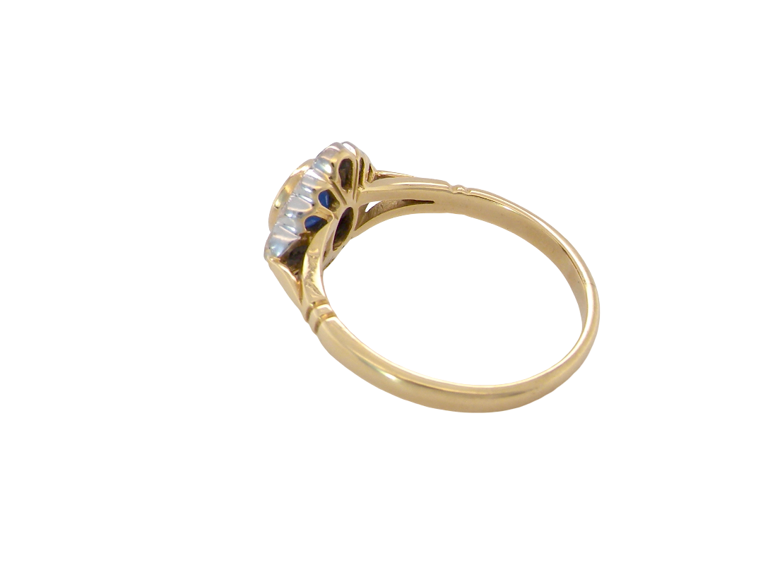 reverse A fine cluster ring featuring to the centre a round dark blue sapphire, 5mm diameter (0.50 carats) mille grain setting.
