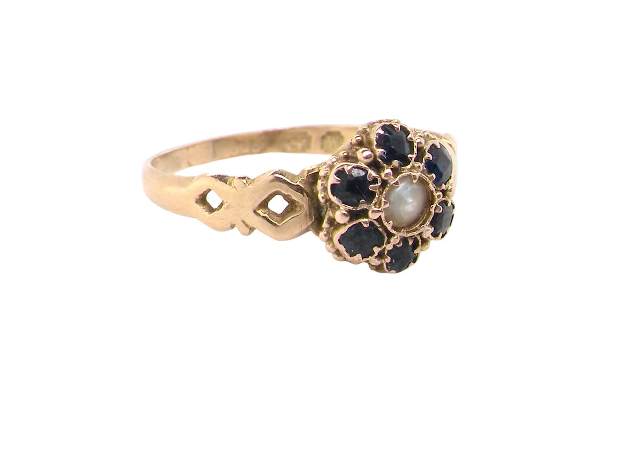 side A 15 carat gold dress ring. The centre a small seed pearl, 3mm diameter. Surrounded by six sapphires, 