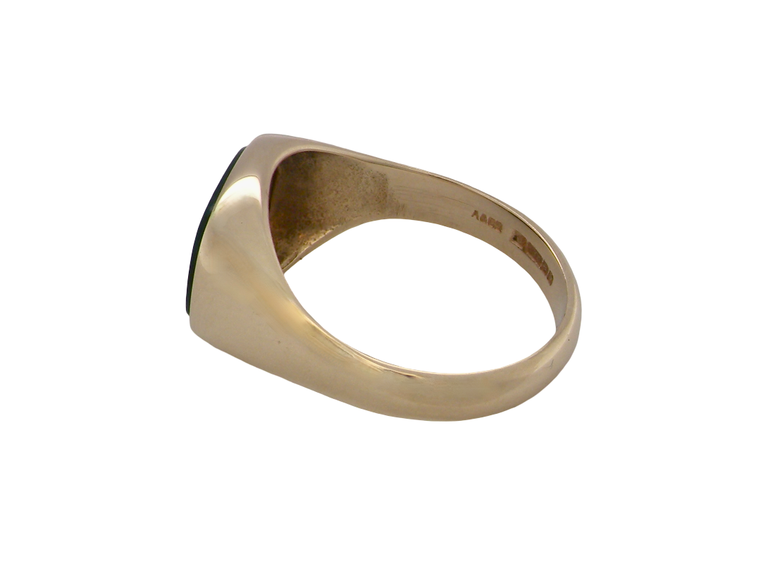 A gold signet ring with a dark green oval inlay, shown from a side angle on a plain white background.