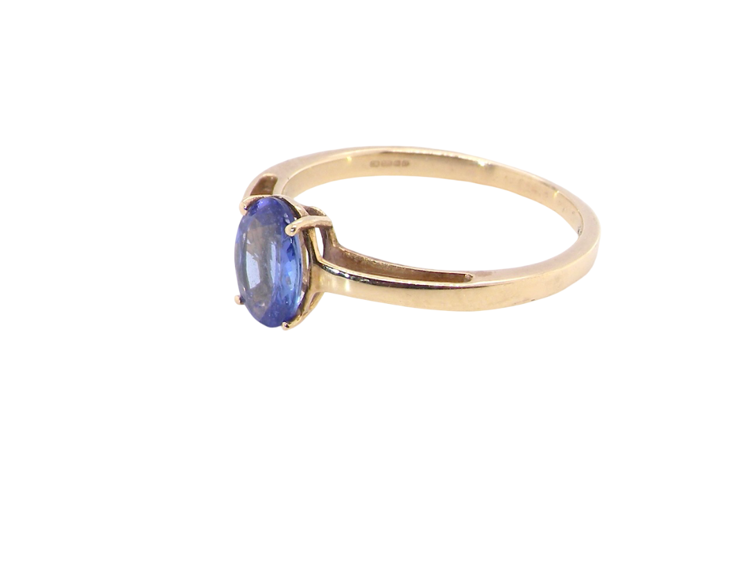 side A 9 carat gold ring containing a single oval cut tanzanite gemstone. Measures 8x6mm, four claw setting.