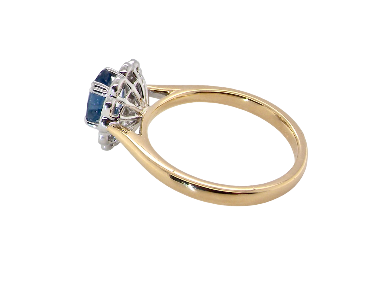 side A beautiful cluster ring featuring an oval-cut mid to dark blue sapphire measuring 7 × 5 mm (approximately ¾ carat).