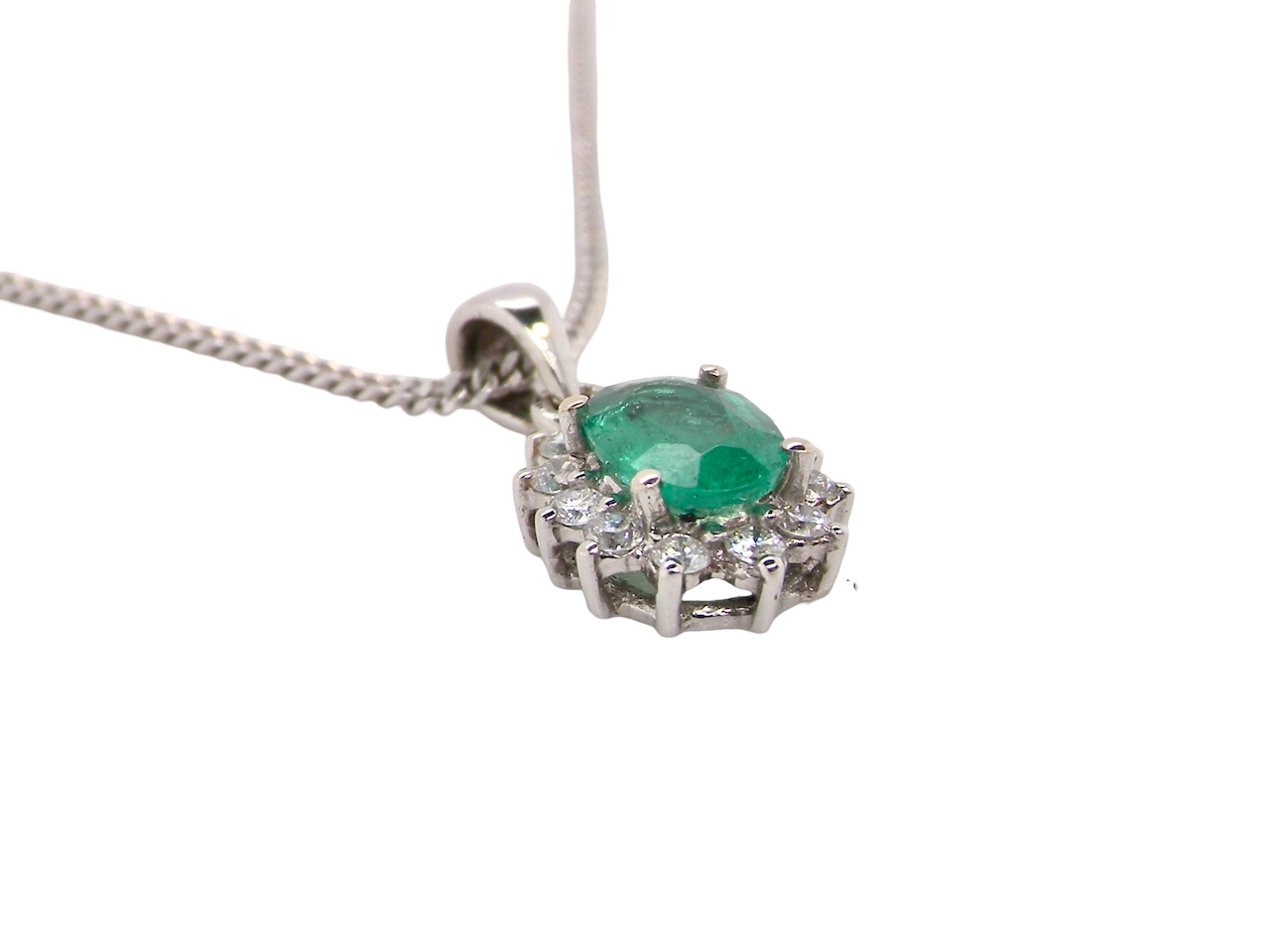 side A beautiful traditional cluster pendant featuring a vibrant oval-cut emerald 
