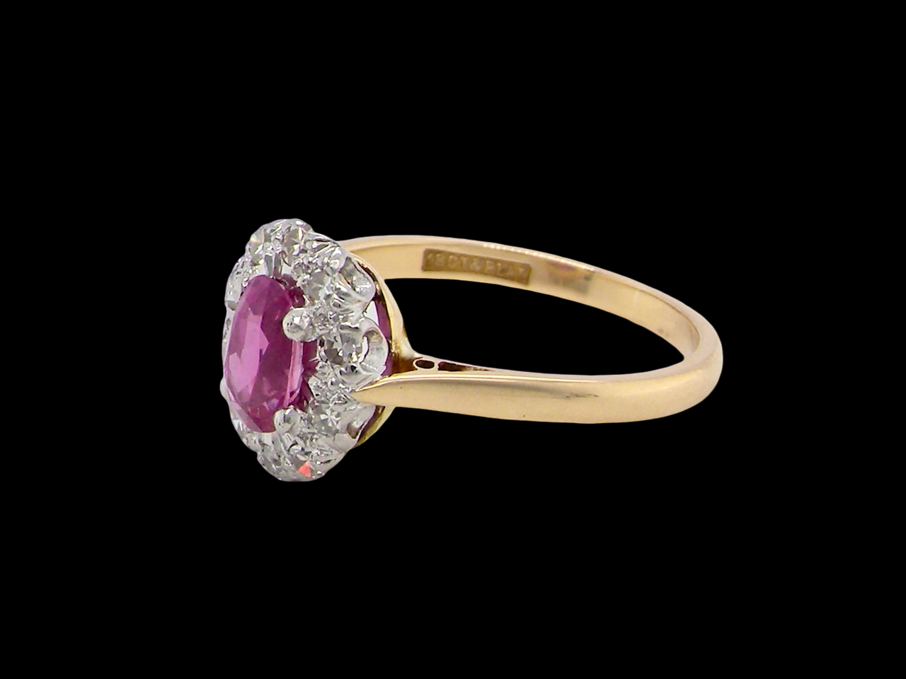 side A beautiful vintage cluster ring showcasing a vivid pink sapphire centre stone, measuring approximately 6.6 × 4.3 mm(estimated 0.65 carats).