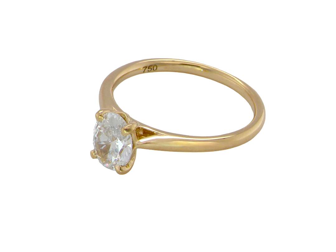 A yellow gold solitaire ring with an oval-cut clear gemstone, shown on a plain white background. The inner band is stamped with '750' indicating sterling gold.