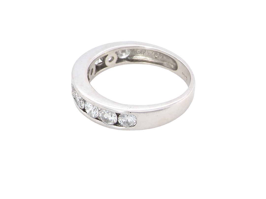 A silver band ring featuring a row of clear oval-cut gemstones along the front, photographed on a plain white background.