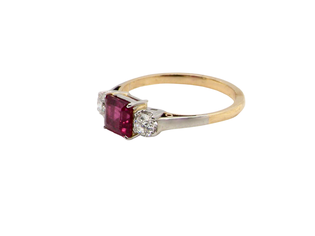 Gold ring with a red gemstone and diamond on a white background