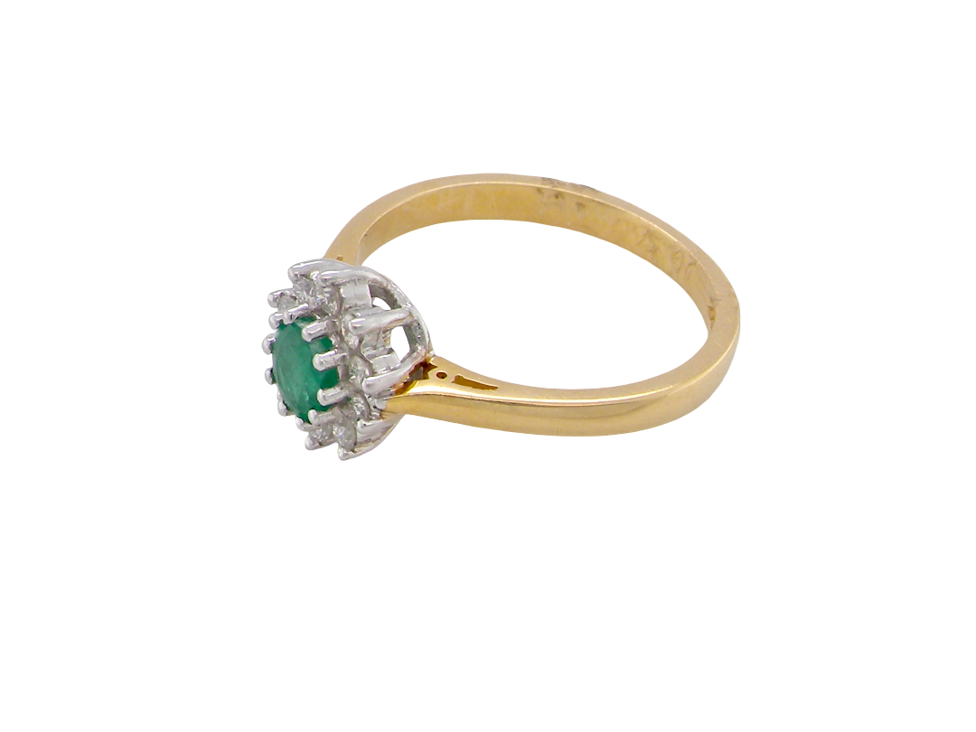 side A classic cluster ring. Features to the centre a round emerald, comlimented by an outerv halo of brilliant cut white diamonds