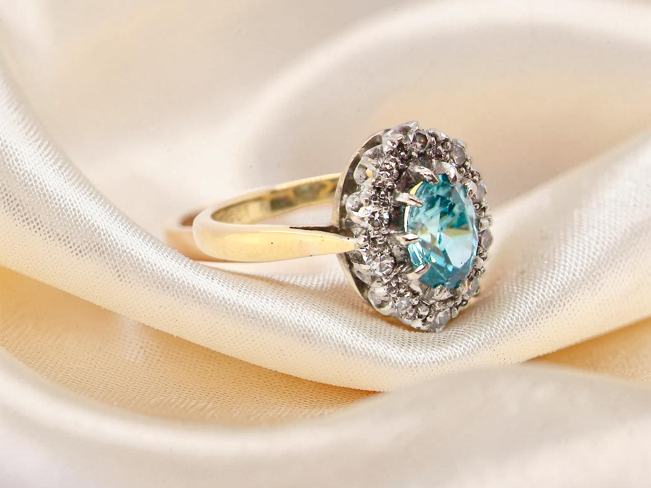 side A cluster ring set with a natural blue zircon centre stone, 7.5x5mm, vibrant aquamarine colour.&nbsp;
