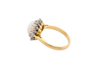 A yellow gold ring featuring a round white opal gemstone in a textured bezel setting with small clear accent stones, shown on a plain white background.