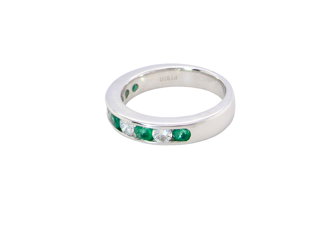 side A fine platinum half hoop eternity ring. This is a new ring*. Channel set gem stones, five bright green emeralds 2.6mm each (0.54 carats total)