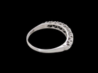 A ring with a curved, openwork filigree top featuring small clear stones, shown against a solid black background.