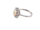 side A lovely white gold cluster ring. Features to the centre an oval white opal, 9x7mm, with an excellent play of colour.
