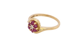 side A modern 9 carat gold cluster ring. At the centre a small diamond, this complimented by an outer halo of six 2.4mm rubies (each 0.05 carats)