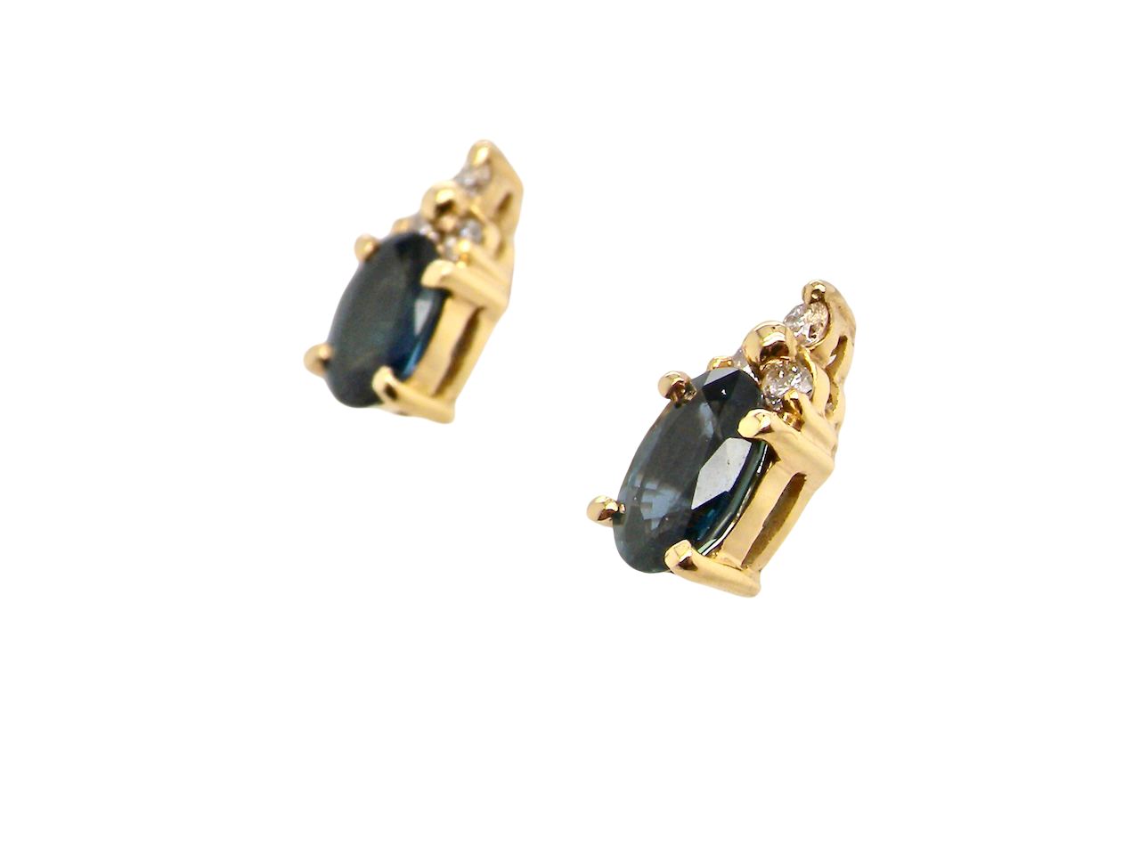side A pair of 18 carat gold earrings*. Set with a dark blue oval cut sapphire 6x4mm, claw set.

Above each, three small white diamonds, overall size 9x4.6mm, weight each 1 gram.
