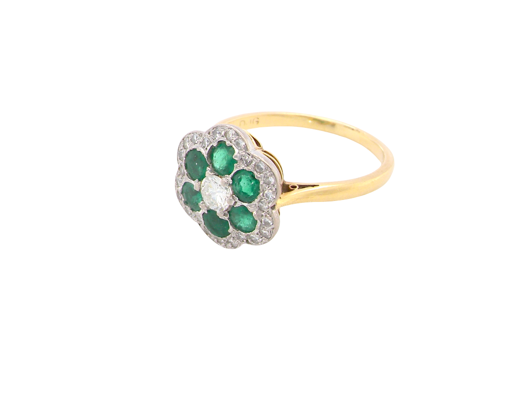 side A pretty cluster ring. Features emeralds and diamonds. Centre stone a brilliant cut white diamond, measures 4mm (0.25 carats).&nbsp;
