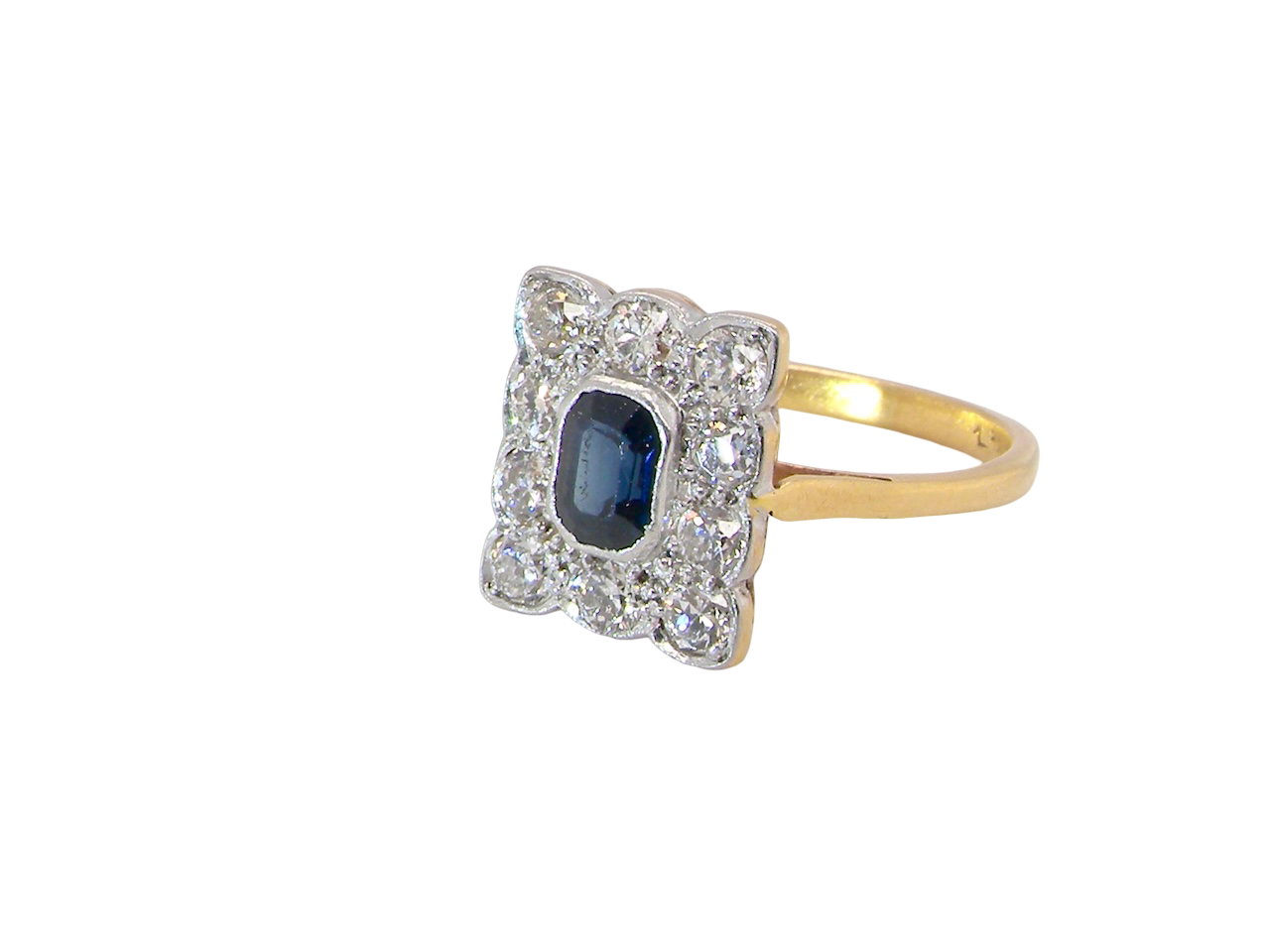 side A rectangular cluster ring that features in its centre a cushion shaped dark blue sapphire, that measures 5x3.5mm (est 0.30 carats)