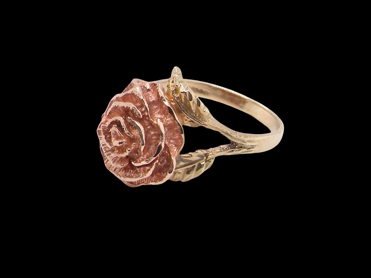 Gold ring with a rose design on a black background