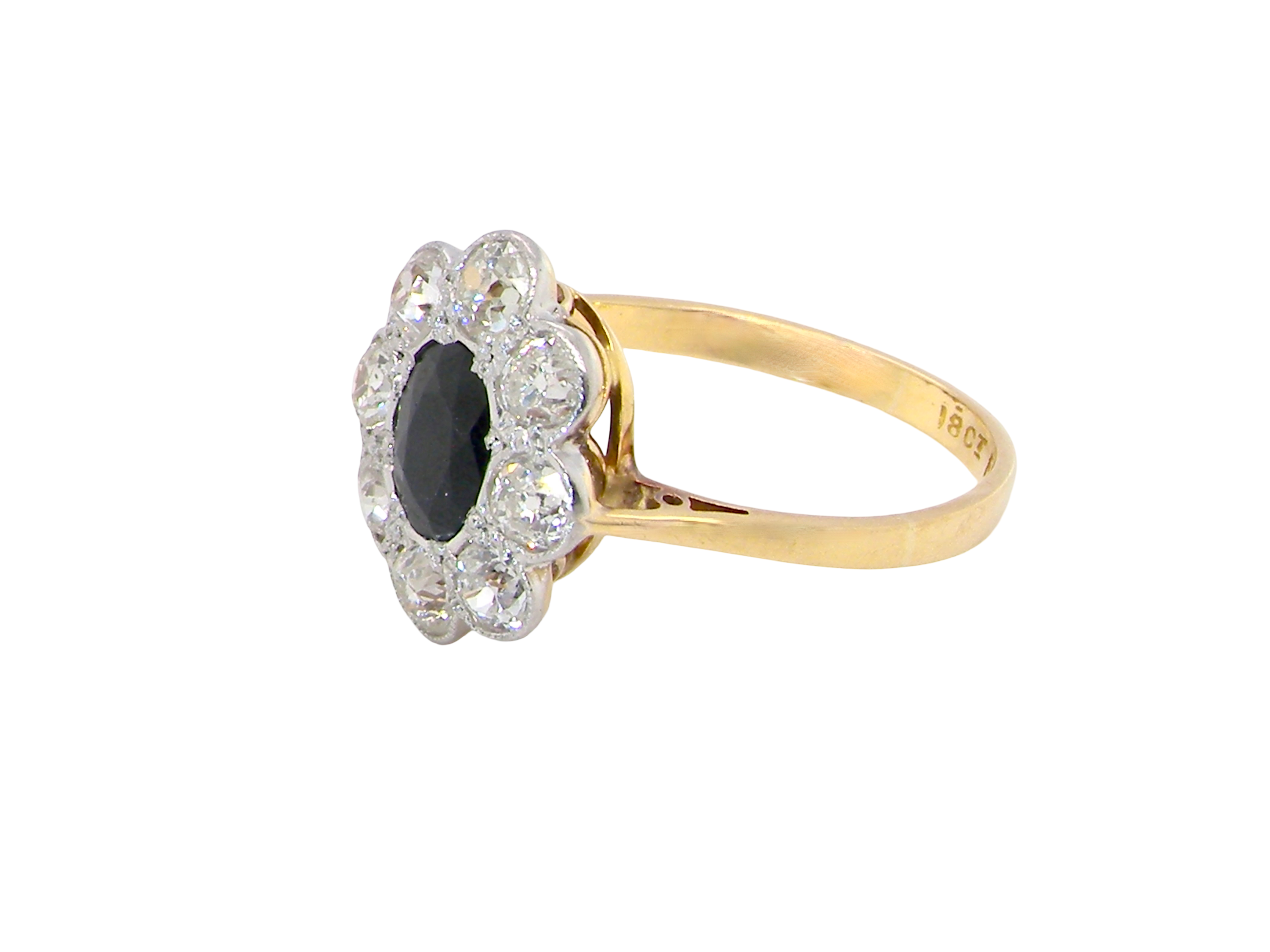 side A striking vintage sapphire and diamond cluster ring dating from the 1930s–1940s, beautifully crafted in platinum and 18 carat gold. At the centre sits a richly coloured oval-cut sapphire of deep inky blue-black hue, measuring approximately 7 x 5mm and estimated at 0.75 carats.