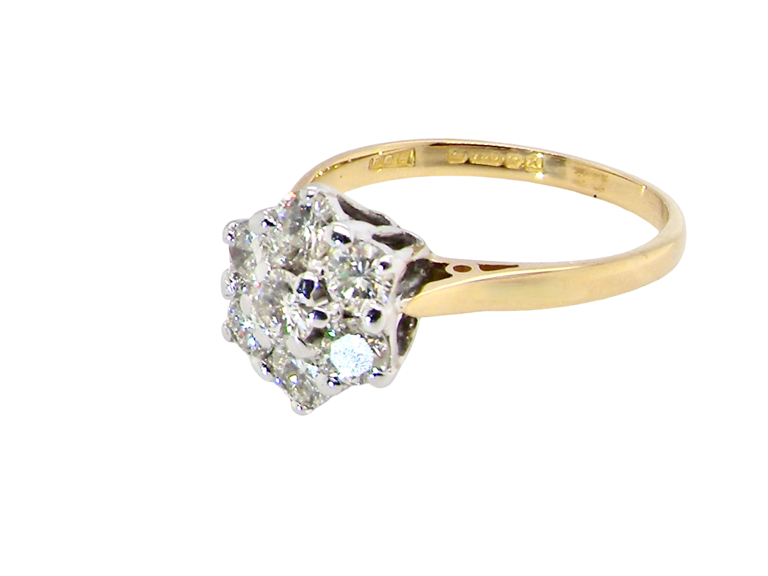 side A traditional cluster ring. Features to the centre a 3.4mm brilliant cut white diamond (est 0.15 carats)

Surrounded by six 3.4mm diamonds to match
