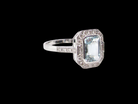side A very pretty cluster ring. Features a step cut aquamarine centre stone, 8x7mm (est 1.21 carats). Plain rim setting.