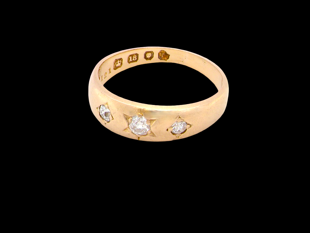 side A vintage 18 carat gold three stone ring. Set with brilliant cut white diamonds, cente 3mm, each side a 2.4mm diamond (total est 0.20 carats) Colour I-j, clarity Si.&nbsp;
