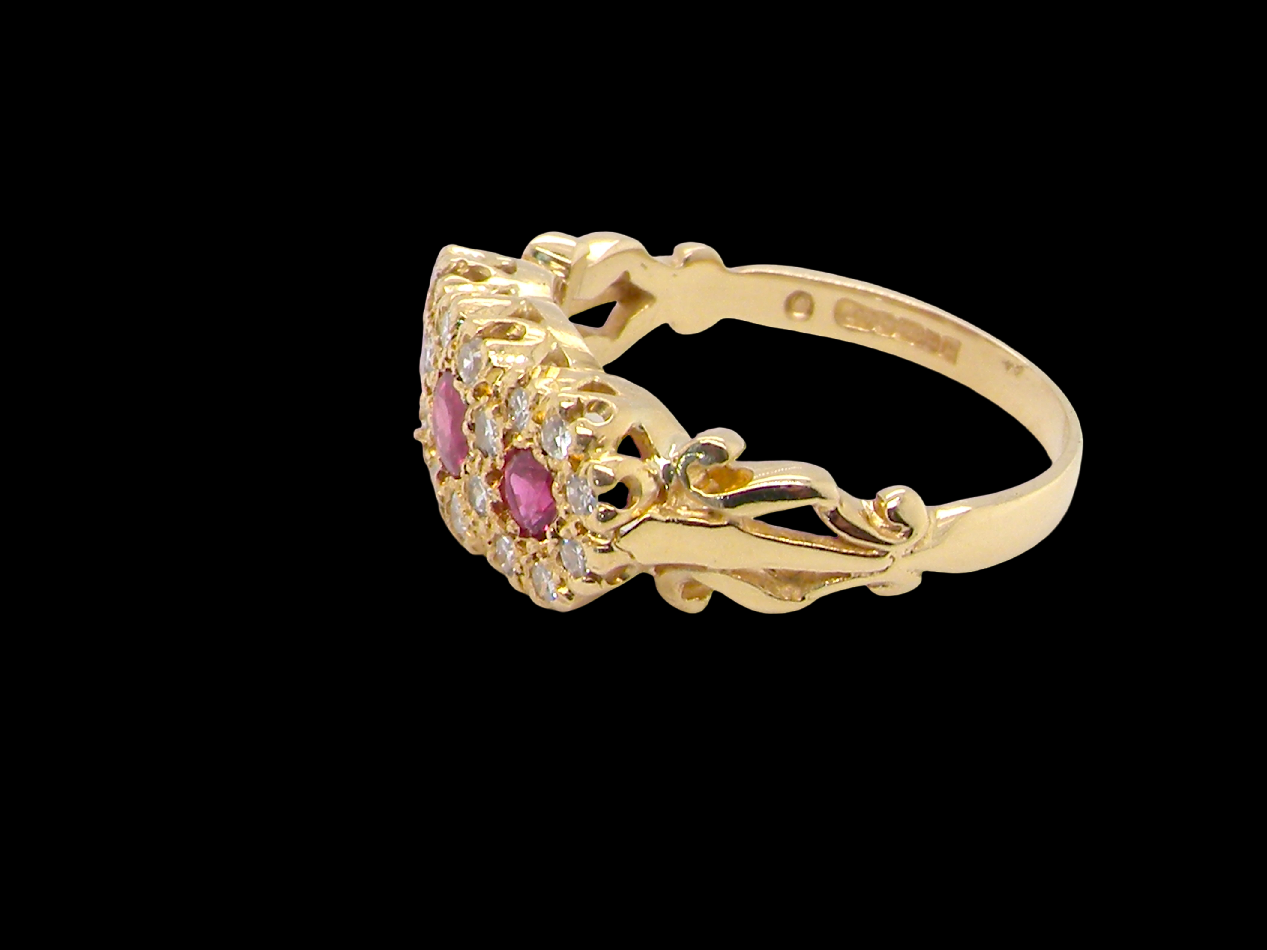 Gold ring with pink gemstones on a black background