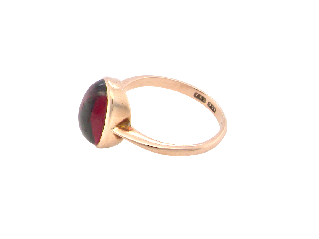 side A vintage dress ring. Set with an oval cabouchon cut garnet, 11x7mm, in a rim style setting.