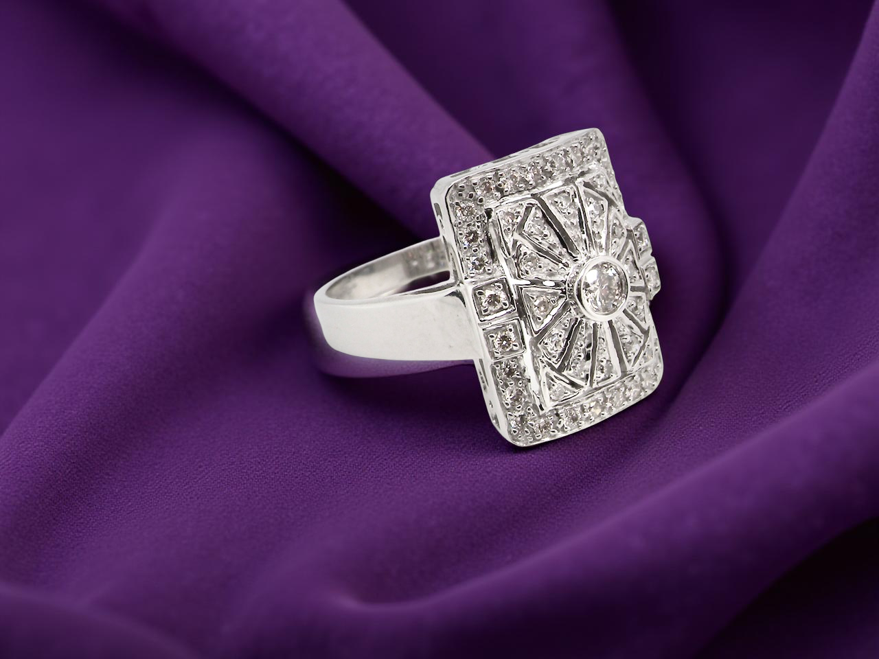 ring with gemstones on a purple fabric background