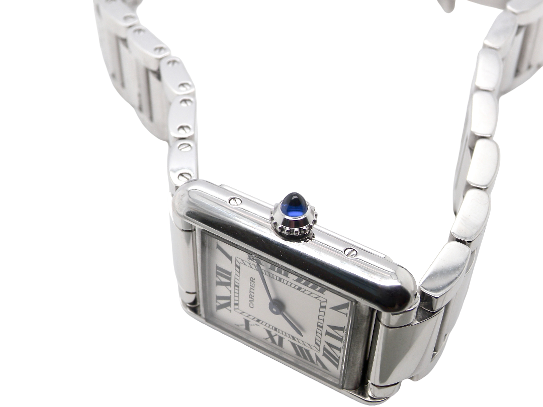 side A womans stainless steel Cartier Tank Must wrist watch. Model number WSTA0051.

Silver coloured dial with Roman Numerals. Blue steeled hands. Case measures 29.5x22mm, case thickness 6.6mm. Quartz movement, synthetic sapphire button.
