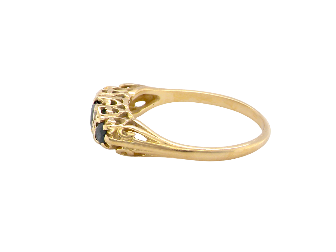 side An 18 carat* boat shaped ring. Features three dark inky blue sapphires, centre 4.7mm, each end a 3mm stone.