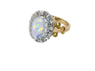side An 18 carat gold cluster ring. Features an oval opal centre stone with excellent play of colour with a predominance of watery purple and flashes of orange, and luminous green.
Measures 11x7mm.