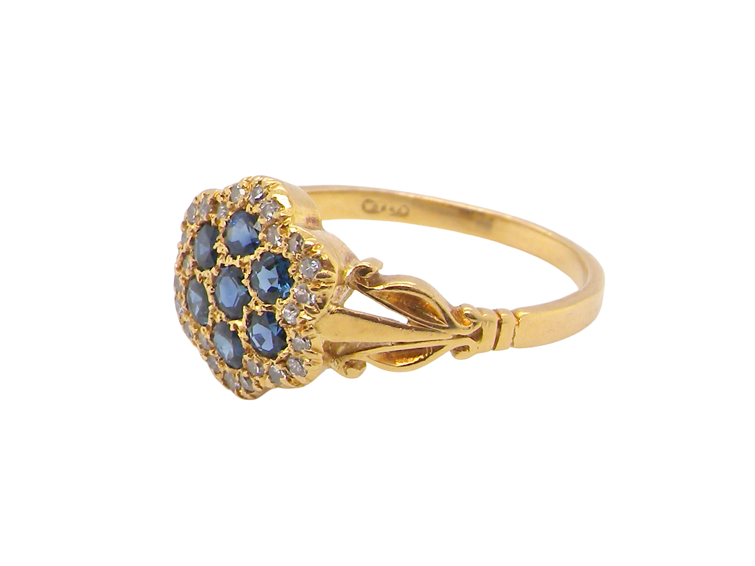 side An 18 carat gold cluster ring.&nbsp; The centre a floral combination of seven sapphires, each 2.5mm, mid to dark blue.