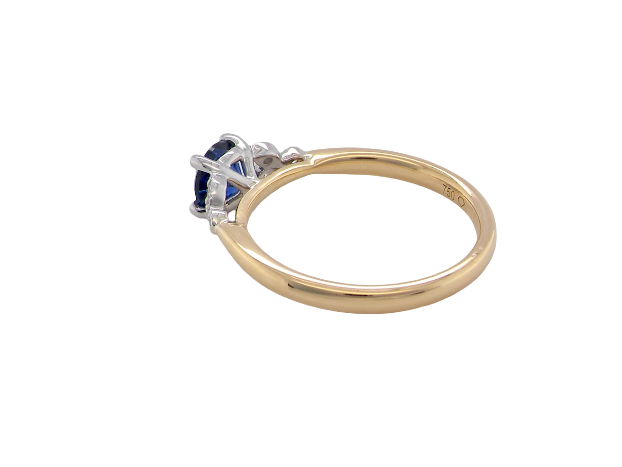 side An 18 carat gold ring set with a vibrant blue sapphire, 