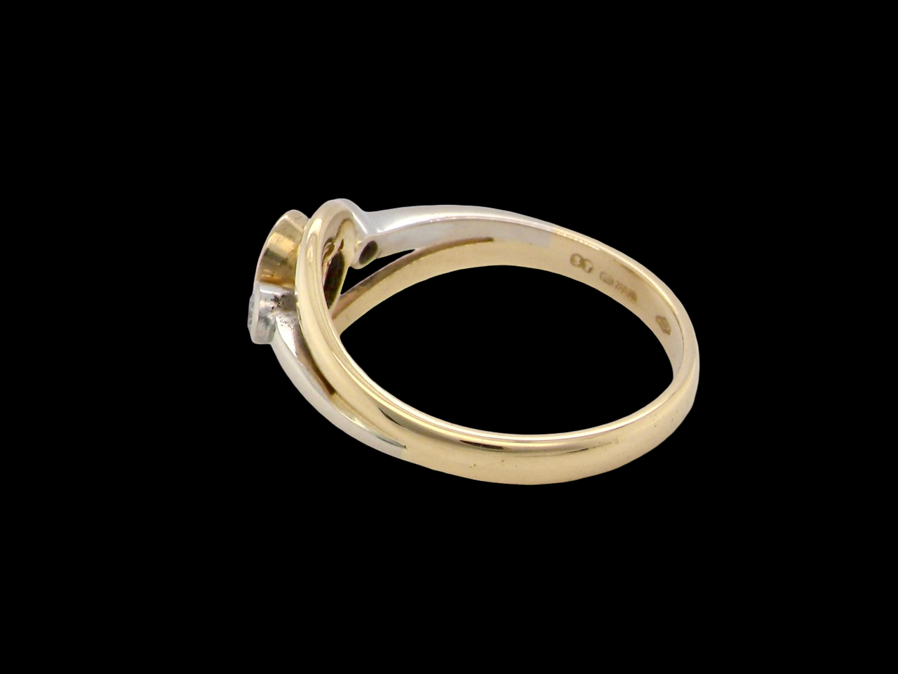 side An  18 carat gold three-stone ring featuring a rich, oval-cut dark blue sapphire at the centre, measuring 5 × 4mm, secured in a classic rim (bezel) setting.