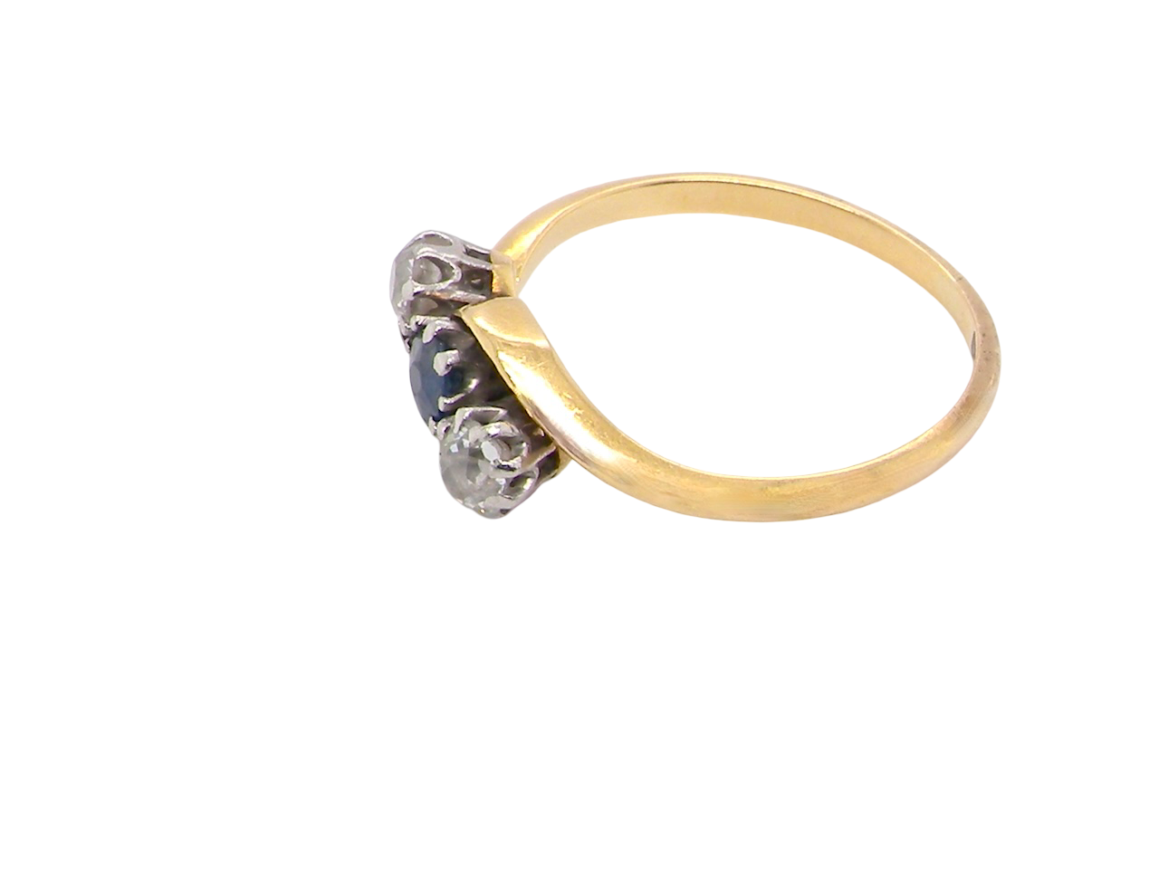 side An 18 carat gold three stone cross over ring.

Centre stone a round sapphire 4mm diameter. Each side a brilliant cut white diamond 4mm diameter (0.25 carats estimated), colour i-k, clarity Si.