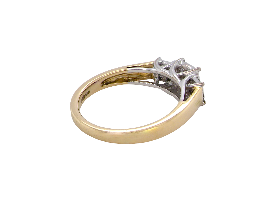 A two-tone diamond ring with a yellow gold band and a silver-colored setting featuring three prongs, photographed on a solid white background.