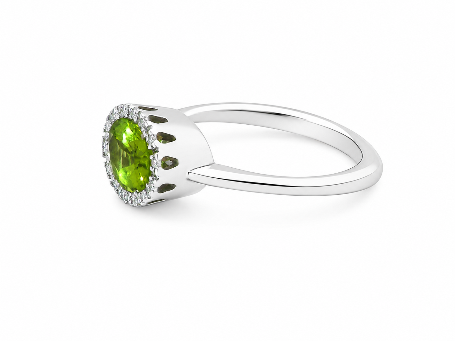 side An 18 carat white gold* cluster ring. Features and oval shaped peridot gemstone, measures 8.5x6.5mm.
