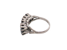 A vintage-style ring featuring a cluster of dark, round gemstones in a prong setting, shown on a plain white background.