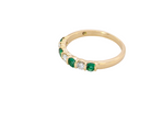 side An 18 carat yellow gold half hoop eternity ring. Set with four bright green emeralds, each 3mm diameter (est each 0.10 carats) .
