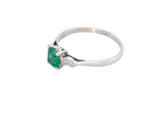 side An elegant and timeless platinum ring featuring a stunning step-cut emerald to the centre, measuring approximately 5.5 x 5.5mm and estimated at 0.80 carats. The emerald displays a vibrant, deep green colour with excellent presence.