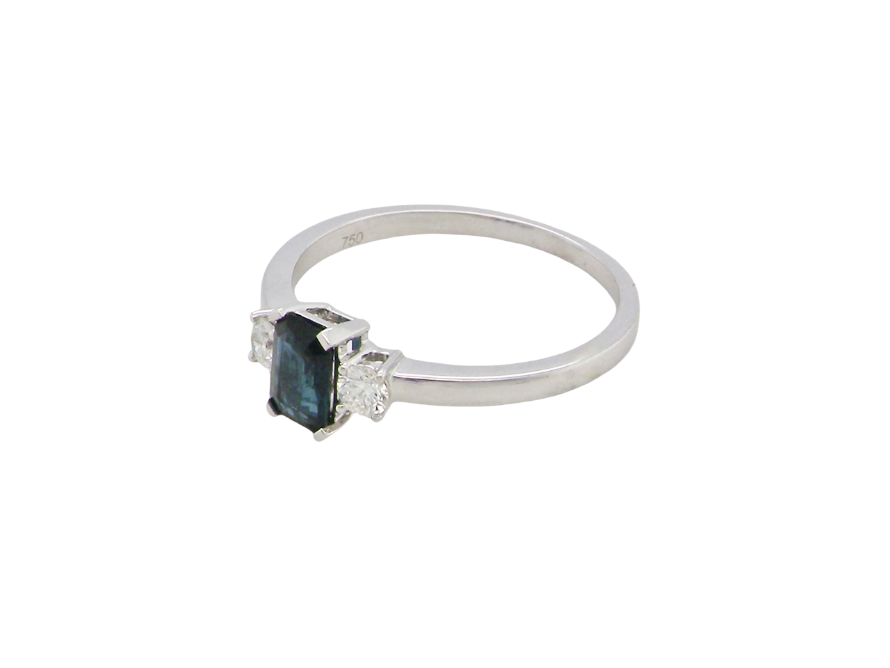 side An elegant three-stone ring crafted in 18 carat white gold, featuring a striking rectangular dark blue sapphire at the centre, measuring 6 × 4 mm and weighing approximately 0.50 carats.