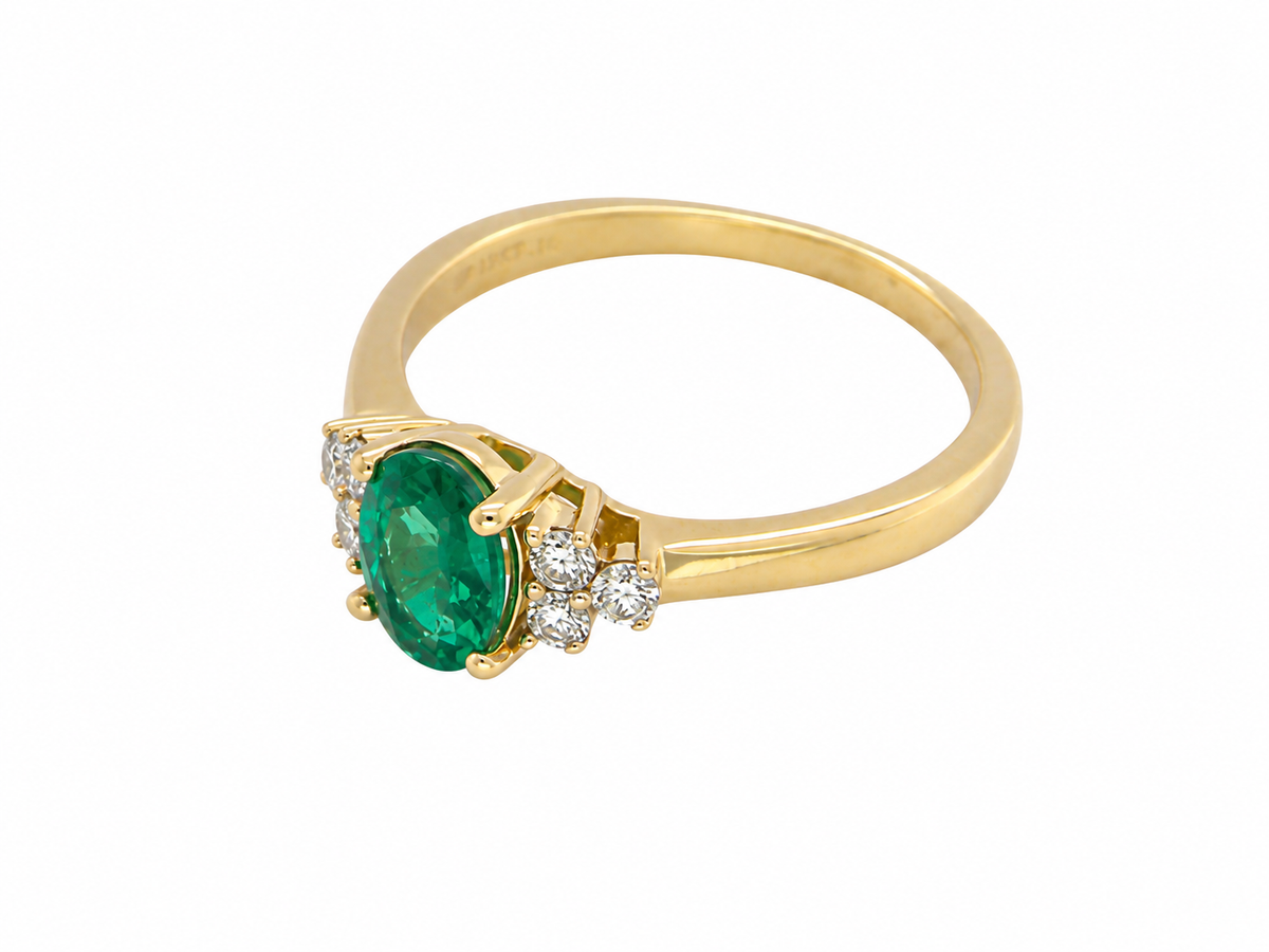 side Featuring a lovely deep velvety green emerald centre stone, this 18 carat gold ring is enhanced by six brilliant cut white diamonds.