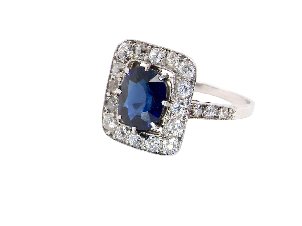 side beautiful original Art Deco cluster ring featuring a rich, dark blue oval-cut sapphire