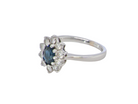 side  fine 18 carat white gold cluster ring. Features an oval cut dark blue sapphire centre stone 