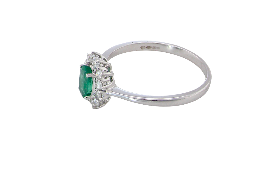side A classic cluster ring set with an oval cut emerald centre stone, measures 6x4mm, grass green colour.

Complimented by an outer halo of twelve brilliant cut white diamonds, each 1.7mm (total est at 0.25 carats)