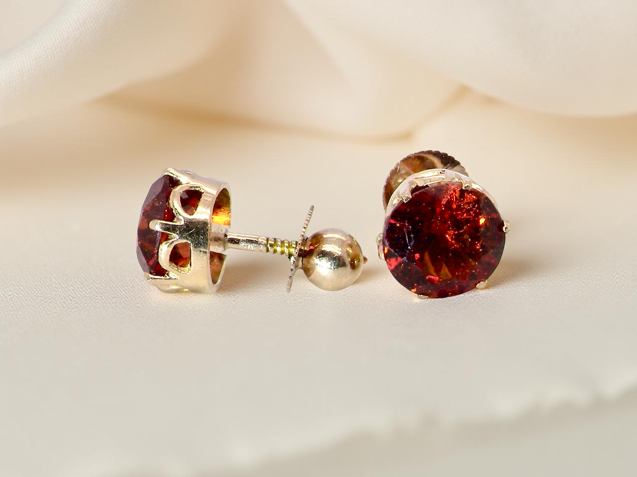  stud earrings. Each one is set with a round garnet, 8mm diameter showing the post
