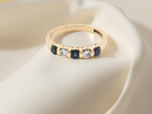 top 18-carat gold half-hoop eternity ring, set with&nbsp;three round mid-blue sapphires
