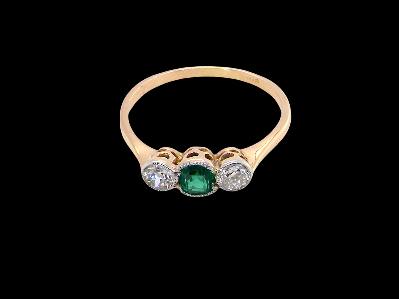 top A charming ring dating from the early to mid-20th century, beautifully crafted and full of period character.

The centrepiece is a vivid bright-green, cushion-shaped emerald 