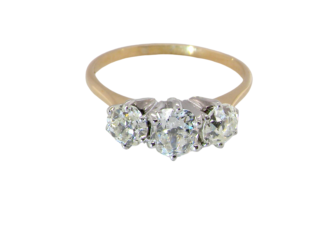 A three-stone diamond ring with a yellow gold band and silver-colored settings, featuring three round-cut diamonds on a plain white background.