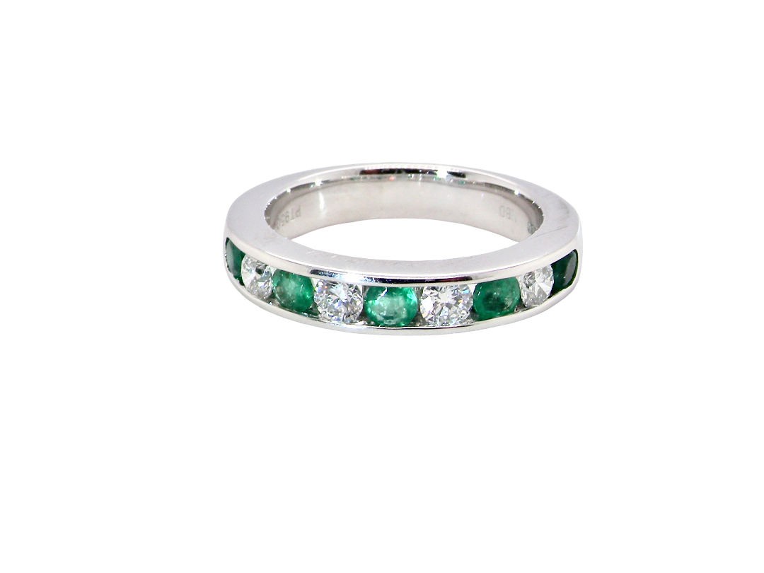 top view A fine platinum half hoop eternity ring. This is a new ring*. Channel set gem stones, five bright green emeralds 2.6mm each (0.54 carats total)